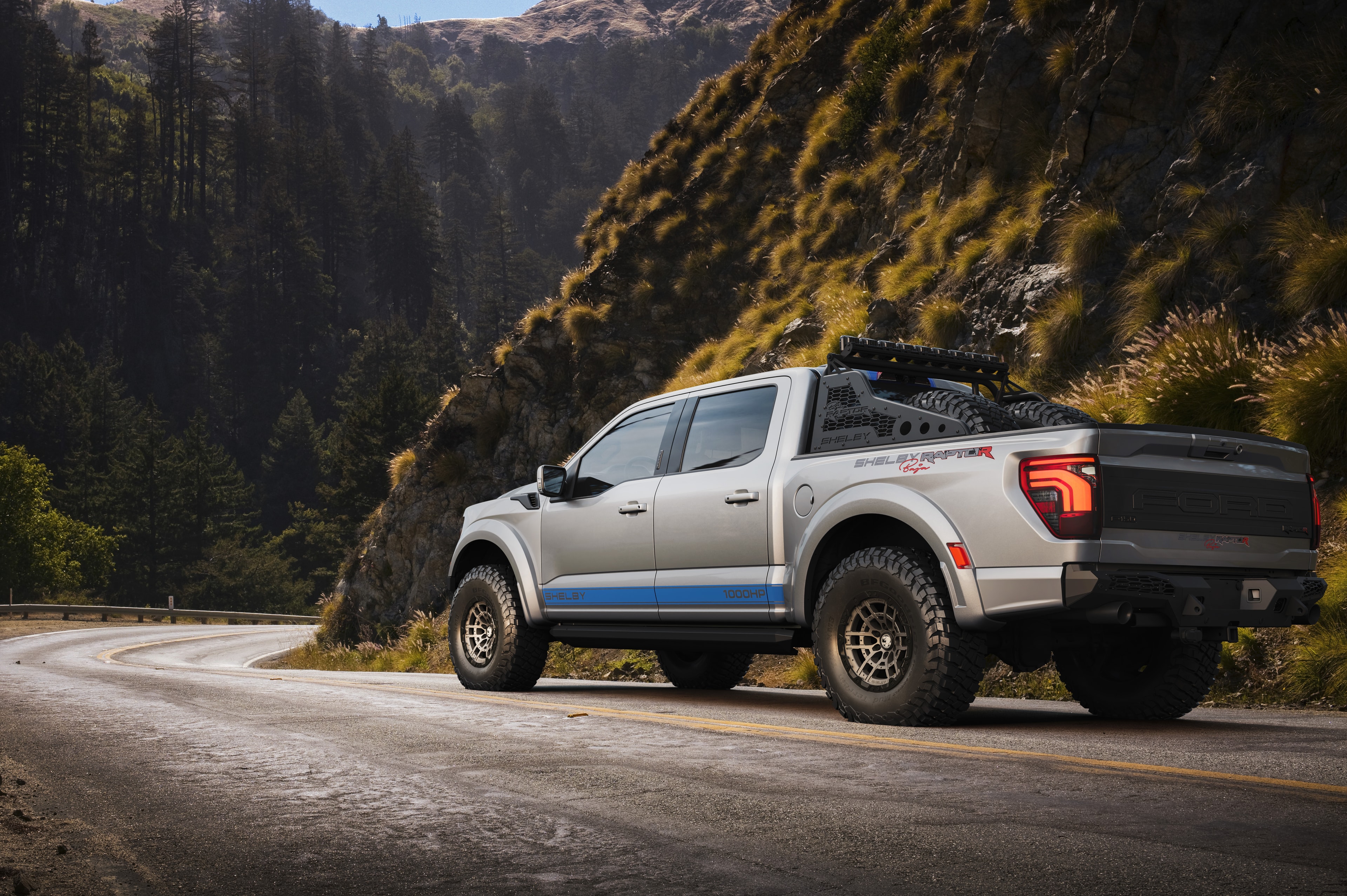 2026 Shelby Raptor R silver blue rear 3/4 mountain road